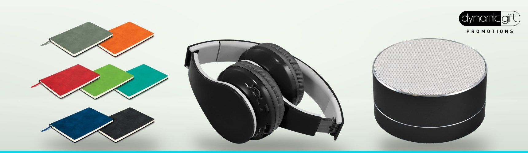 Colourful soft cover notebooks, black foldable Bluetooth headphones and a round Bluetooth speaker