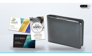 Full colour printed business cards fanned out beside a black leather business card holder on a light background