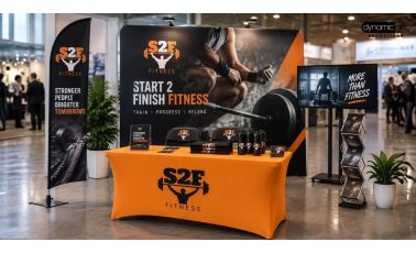 Trade show booth with a branded backdrop, flag banners, a fitted table cover and a brochure stand